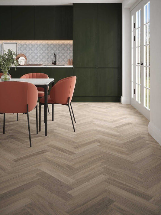 Herringbone laminate flooring in a modern kitchen dining room with dark green cabinets