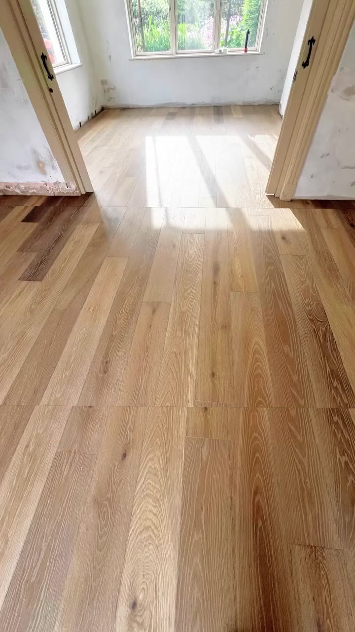 Mountain Ridge Oak plank in a kitchen and living room with matching herringbone in the hall, fitted by Kidd Flooring